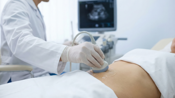 Concept per Egg Freezing: close up su ventra femminile durante una ecografia